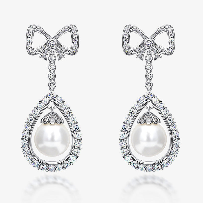 Bow-shaped earrings with pearls and diamonds on a white background, featuring the SHIPEI JEWELRY brand.