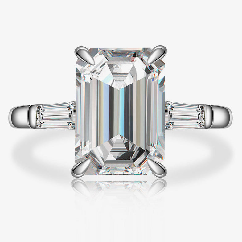Diamond ring with emerald-cut center stone on a white background, featuring the Shipei Jewelry logo.