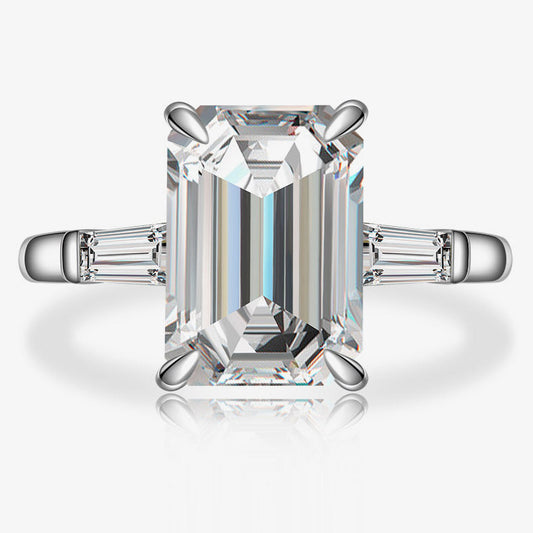 Diamond ring with emerald-cut center stone on a white background, featuring the Shipei Jewelry logo.