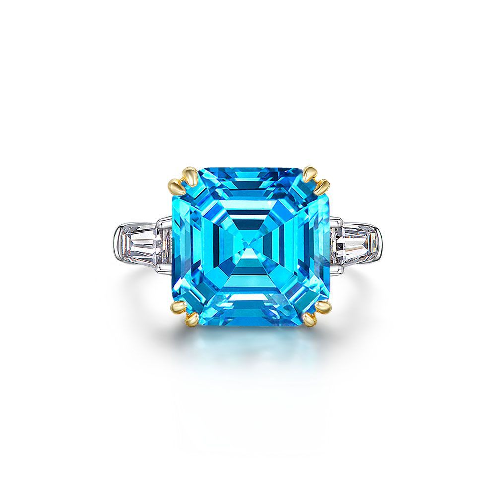 Ring with a large blue gemstone and gold accents on a white background